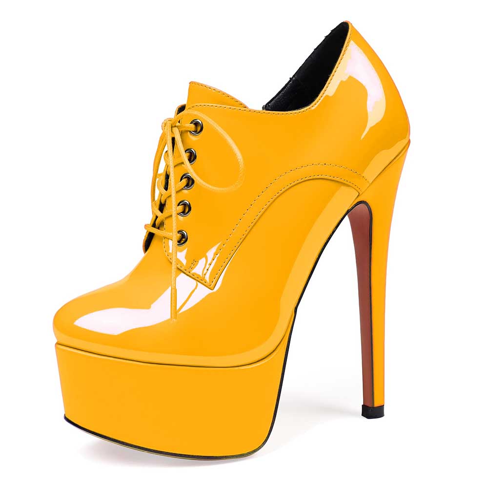 Yellow high heel platform ankle boots with lace-up design and round toe silhouette