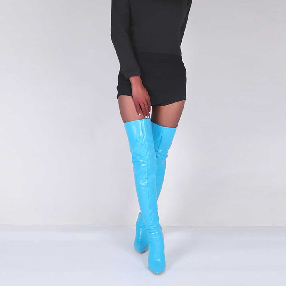 Shiny blue over the knee boots for women paired with a black dress on a model