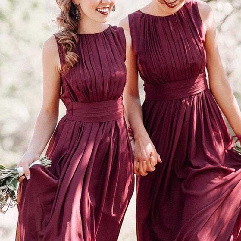 Two women wearing custom long chiffon bridesmaid dress in deep burgundy with pleated bodice and waist sash
