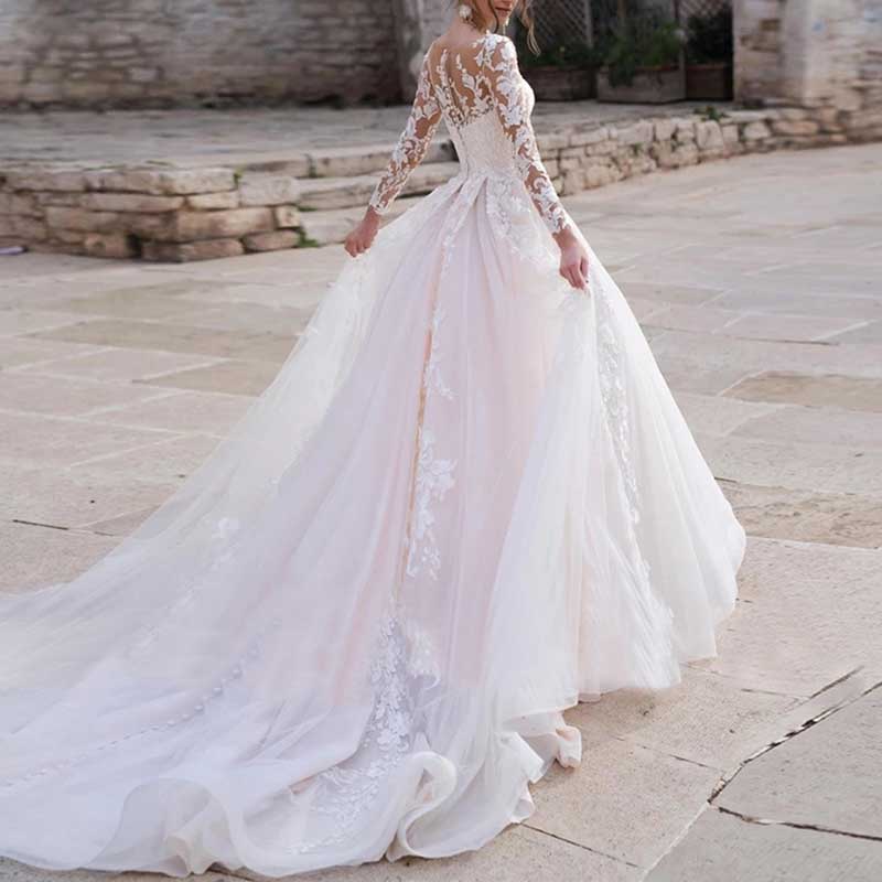Elegant lace wedding dress with sleeves featuring a long flowing train and intricate back detailing