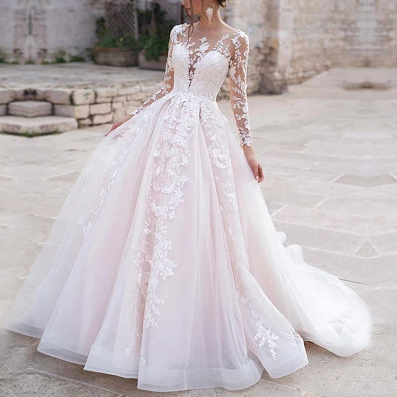 Elegant lace wedding dress with sleeves featuring intricate floral embroidery and a flowing tulle skirt