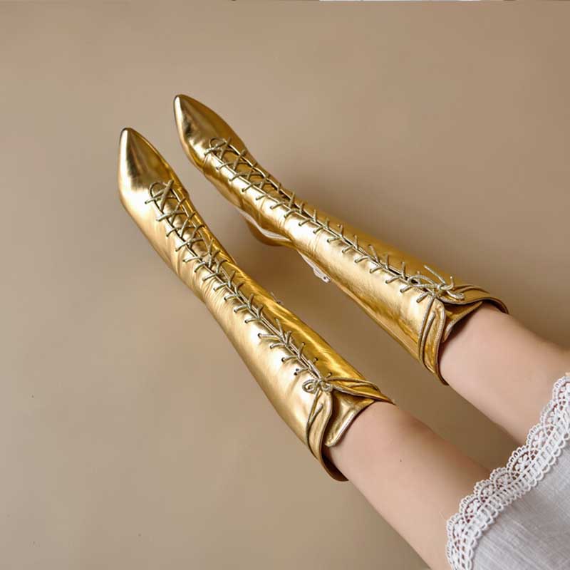 Gold lace up heeled boots for women with pointed toes and mid-calf height on model legs
