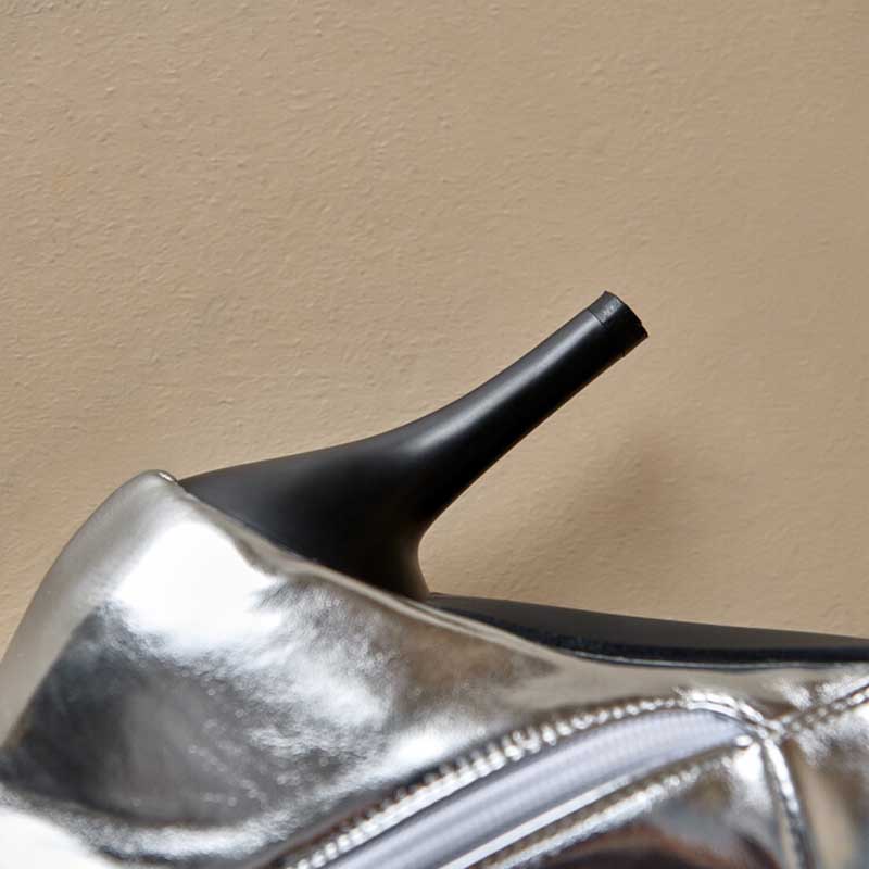 Close-up of silver lace up heeled boots for women featuring sleek black stiletto heel