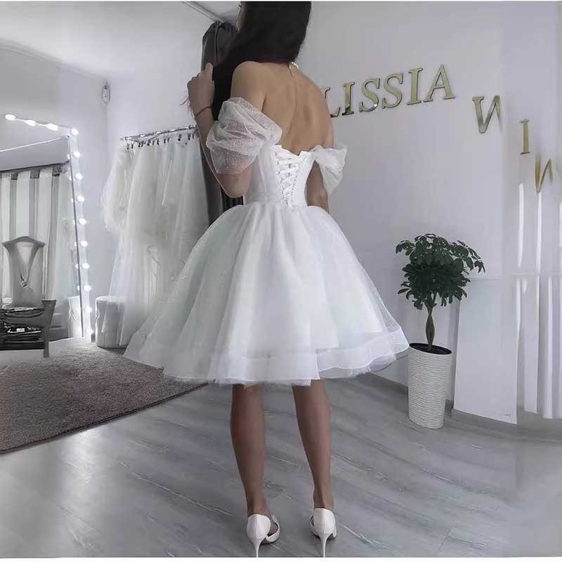 Back view of a short A-line wedding dress with puff sleeves and lace-up back detail