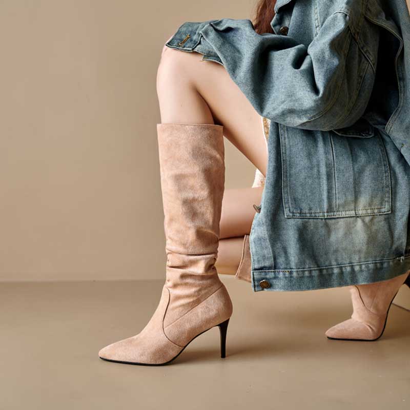 Beige suede knee high boots for special occasions with pointed toes and slim heels worn with denim jacket