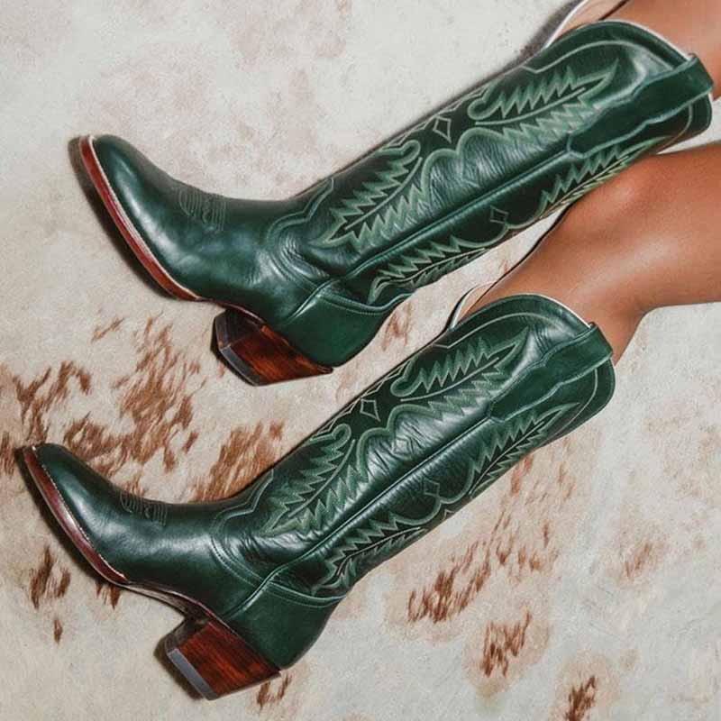 Dark green vintage knee high cowboy boots with intricate stitching and wooden heels