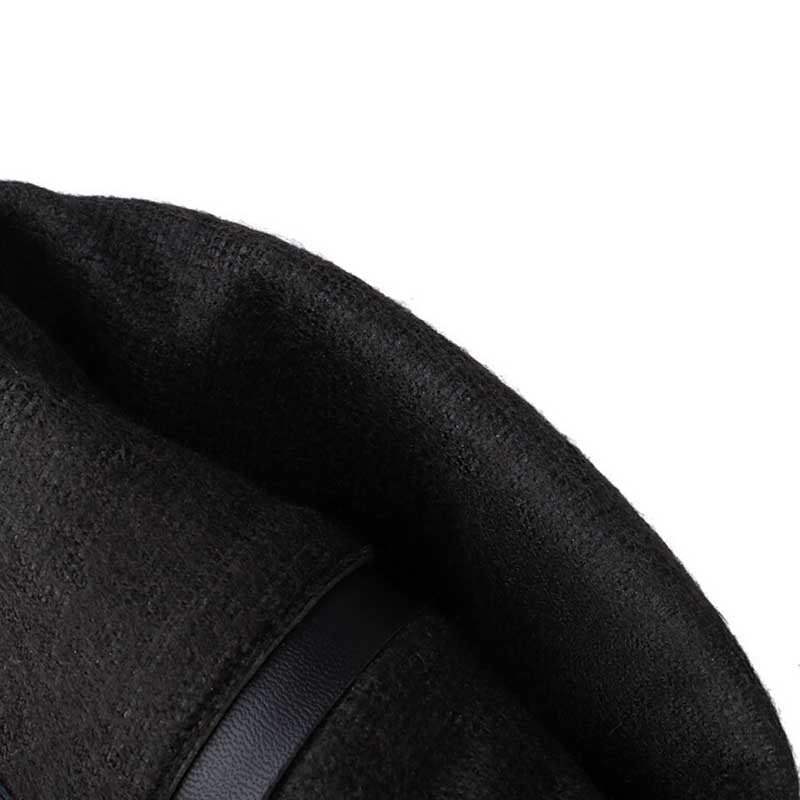Close-up of black women's suede knee-high boots showing soft textured material and strap detail