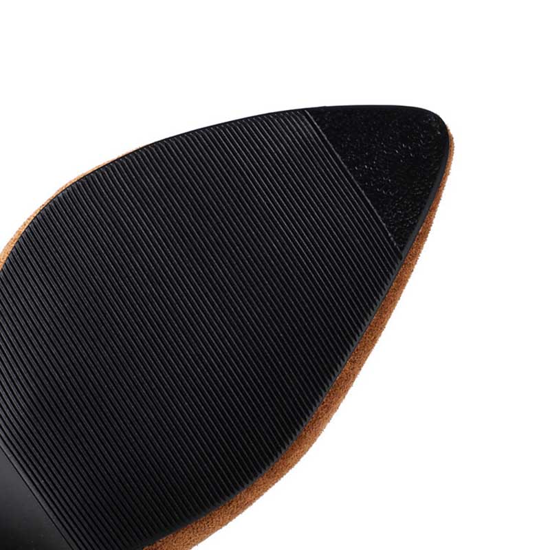 Close-up of sole detail on women's suede knee-high boots showing textured black rubber outsole