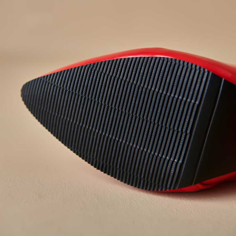 Close-up view of the black sole on women's chunky heel boots for prom with red upper