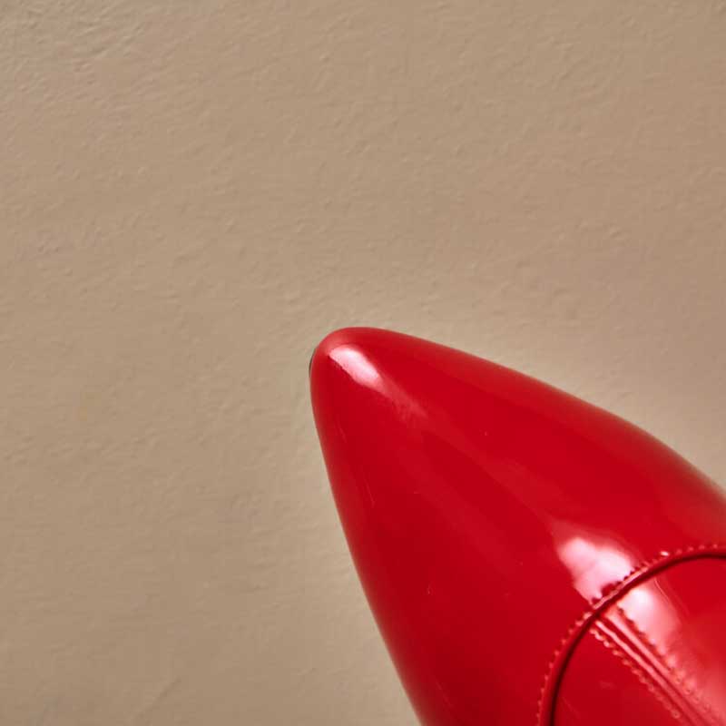 Close-up of red women's chunky heel boots for prom with glossy finish and pointed toe