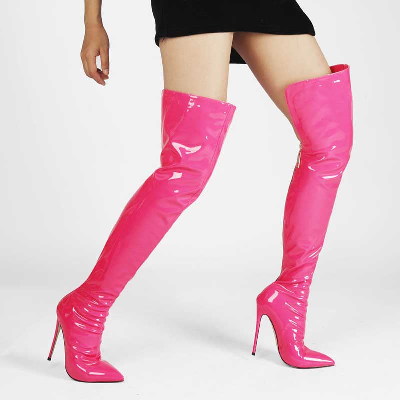 Bright pink womens stiletto thigh high boots in glossy finish worn with a black dress