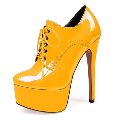 Yellow high heel platform ankle boots with lace-up design and round toe silhouette