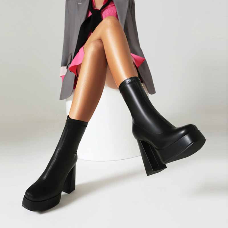 Black chunky heeled boots for women with platform soles styled on model wearing a pink skirt