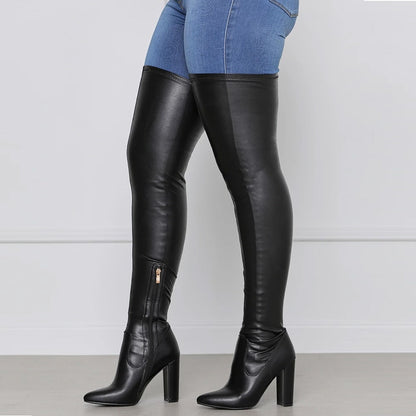 Black chunky heeled over the knee boots paired with blue skinny jeans