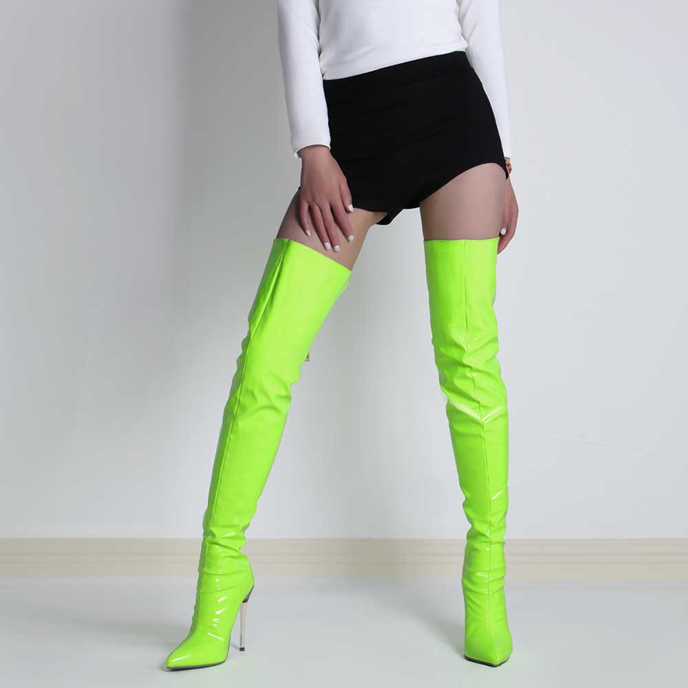 Neon green pointed toe stiletto high heel boots worn with black shorts and white top