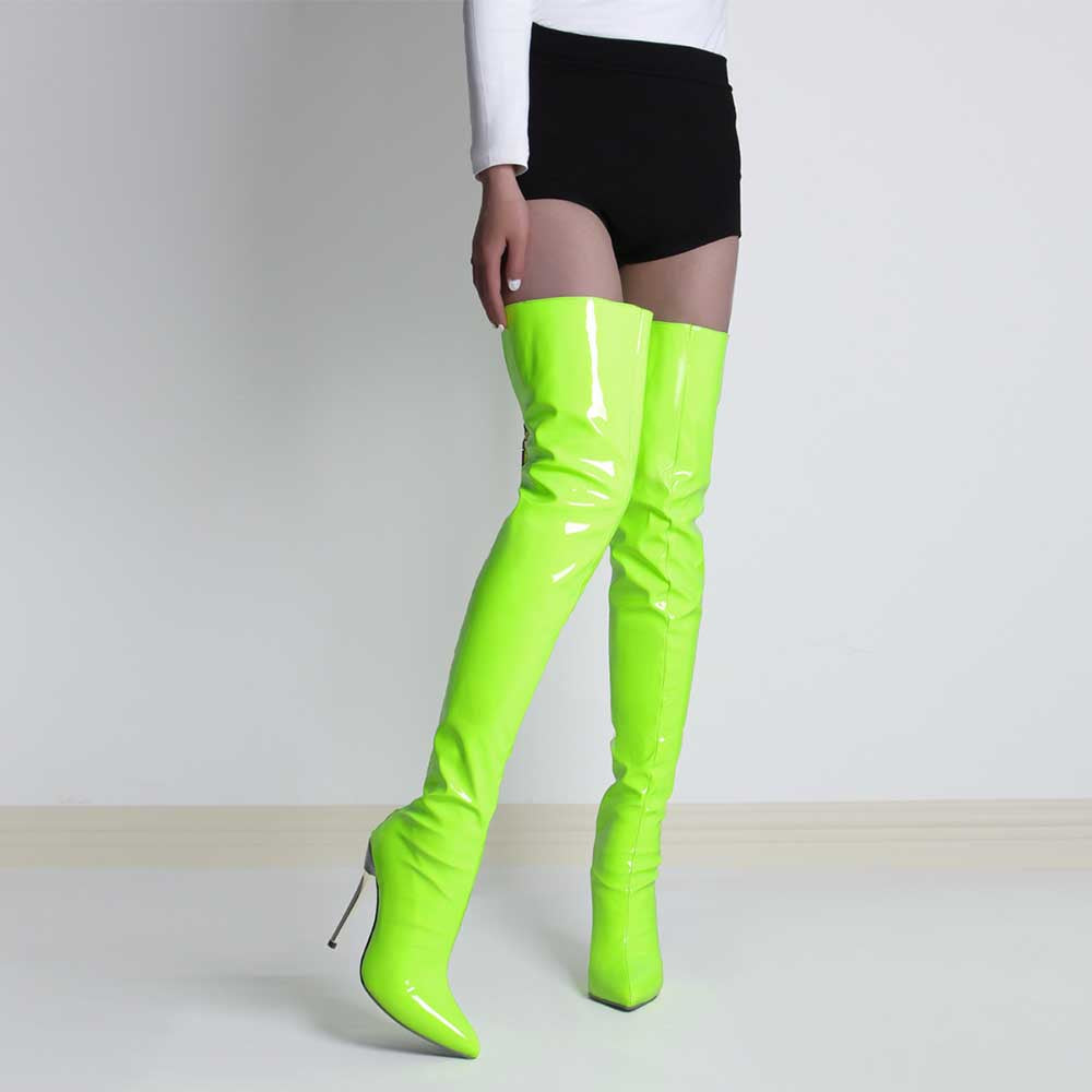 Bright neon green pointed toe stiletto high heel boots worn with black shorts and white top