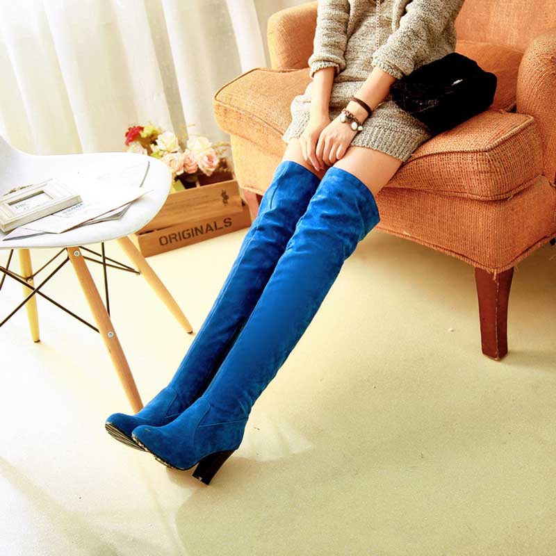 Blue suede plus size thigh high boots for women worn with a gray sweater dress sitting on an orange couch