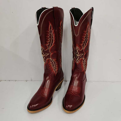 Vintage knee high cowboy boots in dark red leather with intricate tan and orange stitching design