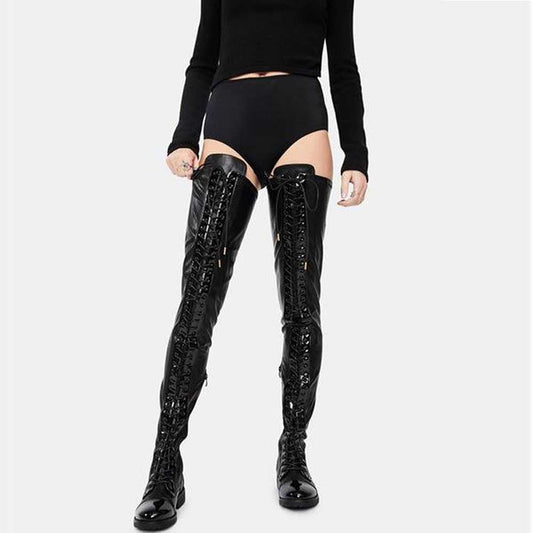 Black shiny over the knee laced boots for women with high gloss finish on model wearing black outfit