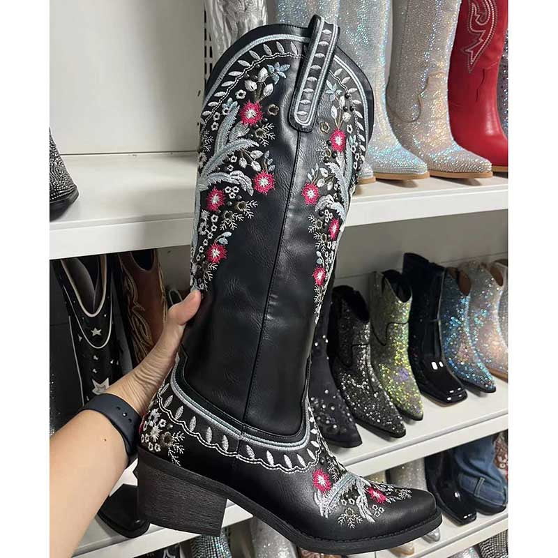 Black women's embroidered cowboy boots with pink and white floral stitching and a low heel