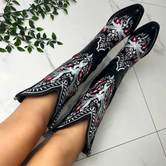 Black women's embroidered cowboy boots with intricate white and pink floral designs on legs