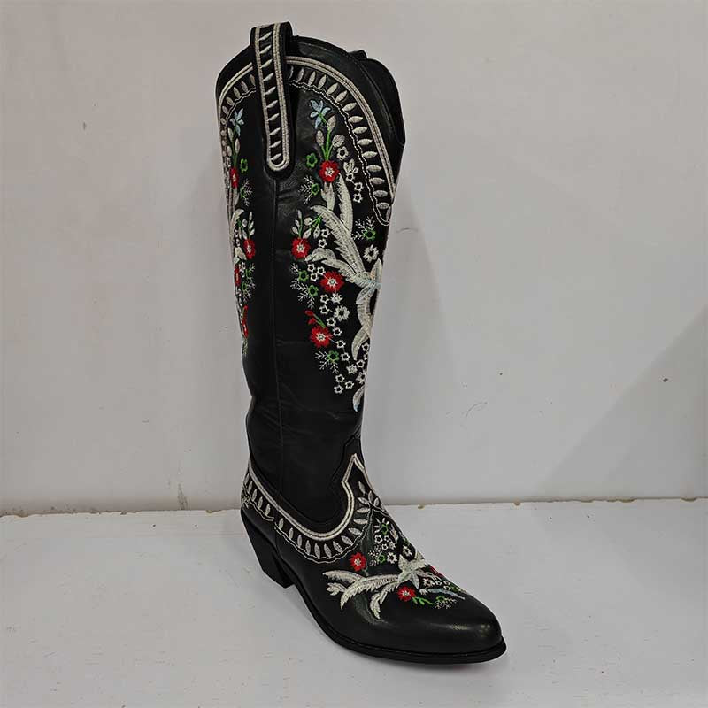 Black women's embroidered cowboy boots featuring colorful floral stitching and decorative trim