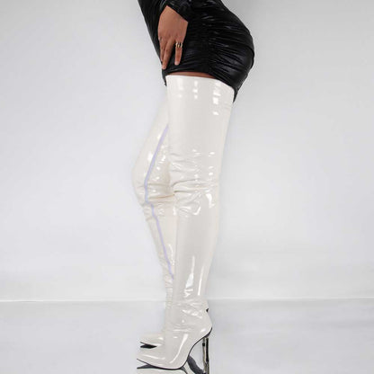 White patent leather women's over the knee stiletto boots paired with a black mini dress